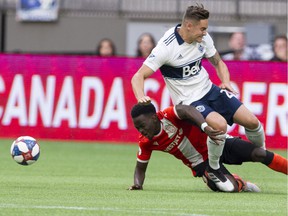 Whitecaps defender Jake Nerwinski gets undercut by Cavalry FC's Nathan Mavila during their 2019 Canadian Championship game at BC Place, a loss that bounced the Caps out of the competition.