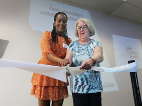 Princia Gateka, left, a student at the school, and Doris Sauve, president of the Conseil scolaire catholique Providence, cut a ceremonial ribbon during Wednesday's event.