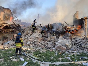 Emergency crew tended to a fire near a burning debris, after a school building was hit as a result of shelling, in the village of Bilohorivka, Luhansk, Ukraine, May 8, 2022.
