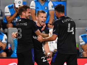 CF Montreal defender Alistair Johnston (22) celebrates with midfielder Djordje Mihailovic (8) and defender Rudy Camacho (4) after scoring a goal in the second half at Bank of America Stadium on May 14, 2022.
