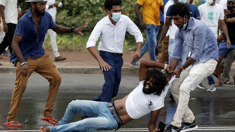 A supporter of Sri Lanka's ruling party pulls the shirt off a member of an anti-government protester during a clash between the two groups, amid the country's economic crisis in Colombo, Sri Lanka, April 9, 2022. REUTERS/ Dinuka Liyanawatte