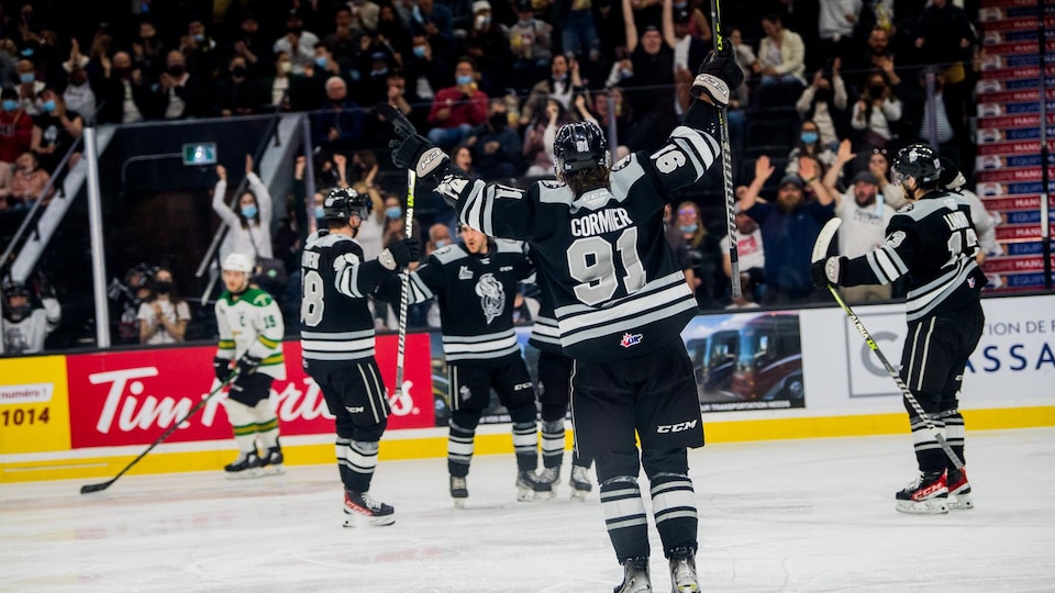 A hockey player goes to join his teammates celebrating a goal.