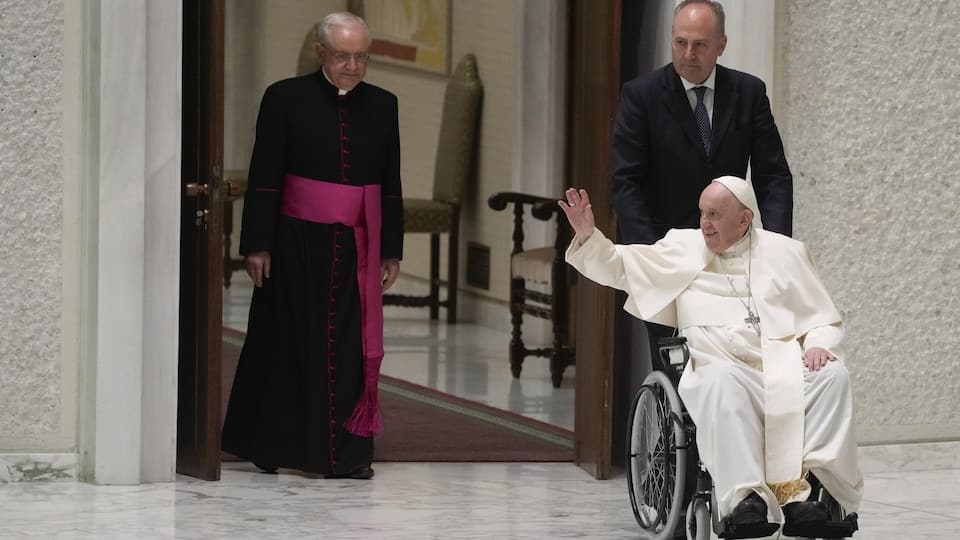 Pope Francis enters the Paul VI Hall in the Vatican in a wheelchair. 