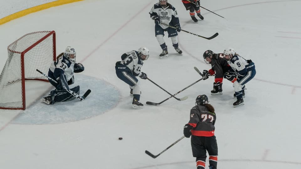 Two teams compete in ice hockey at the Rimouski arena. 
