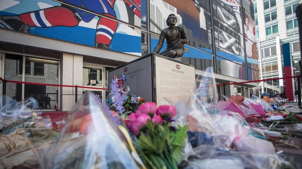 Guy Lafleur's statue surrounded by bouquets outside the Bell Centre.