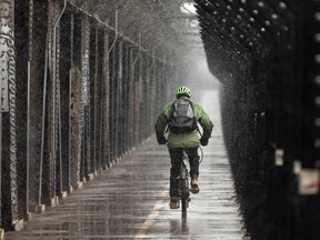 A cyclist crosses the High Level Bridge as a snowstorm moves into the Edmonton area on Tuesday, April 19, 2022.