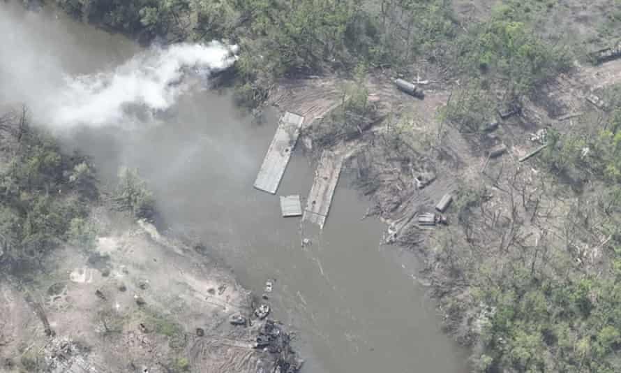 An aerial photo of a dilapidated pontoon crossing with dozens of destroyed Russian armored vehicles on the banks of the Siverskyi Donets River,