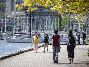 People enjoy the sunny weather along the Yaletown seawall in Vancouver in a recent file photo.