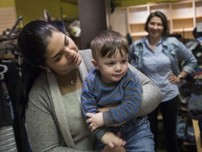 Yulia El Hilali holds son Anwar at the Ukrainian Newcomers Centre, as volunteer Tatiana Romano looks on. 