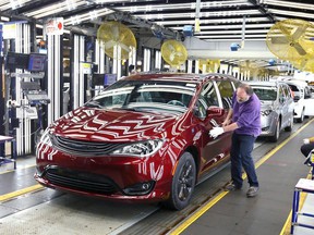 Inspector Frank Calzavara is shown with a Chrysler Pacifica Hybrid in velvet red in the 'final car' area of ​​FCA Canada's Windsor Assembly Plant.