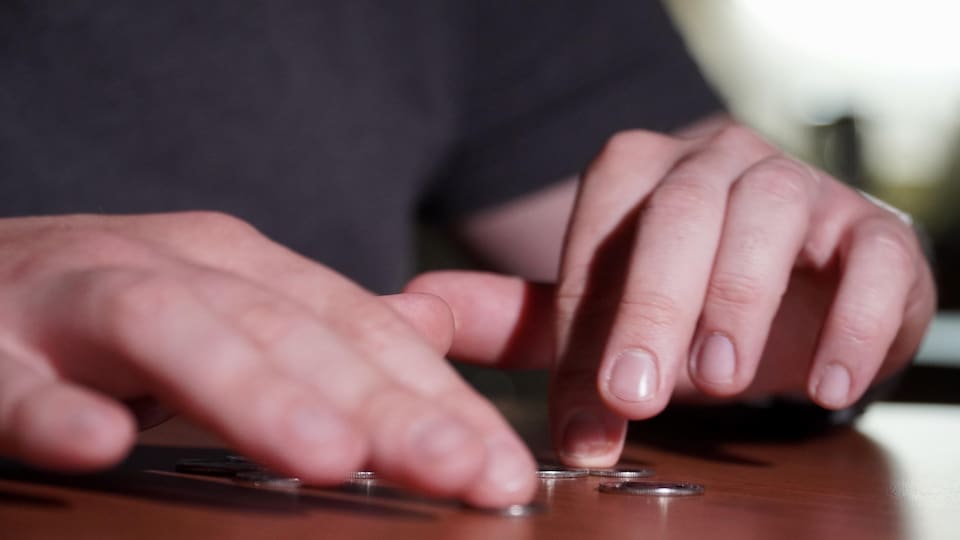 Hands counting coins on the table.