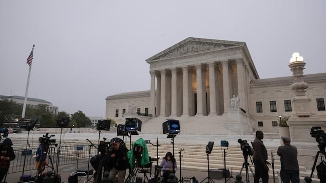 Several teams of journalists and cameramen in front of the Supreme Court of the United States. 