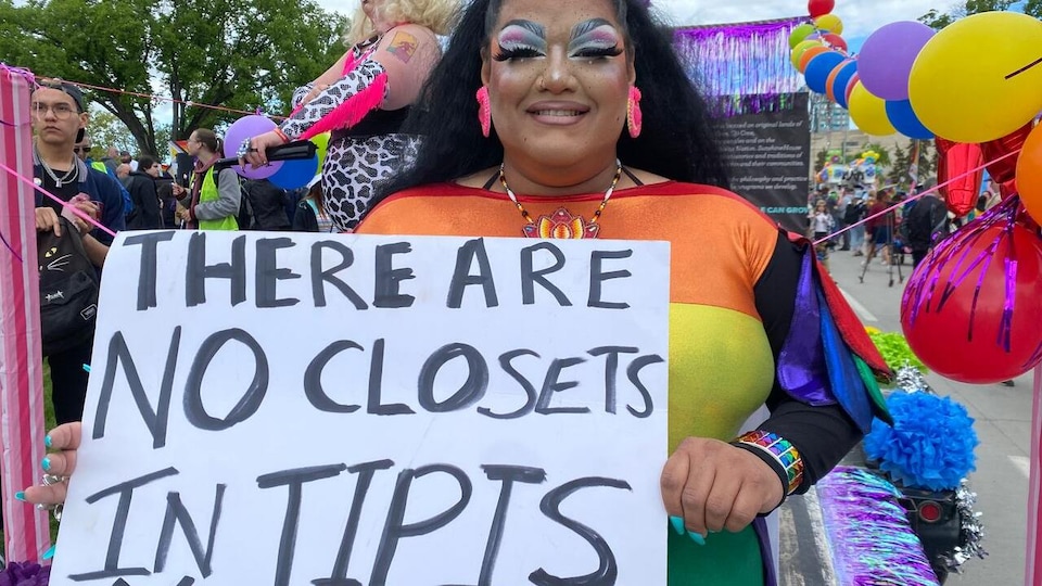 Feather Talia is holding a poster on which she has written: there are no closets in tipis, or, in French, there is no closet in a tipi. 