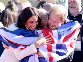 Prince Harry and Meghan hug Lisa Johnston of Team United Kingdom during the Invictus Games in The Hague in April 2020.