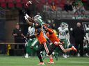 Saskatchewan Roughriders' D'haquille Williams, back left, reaches but fails to make the reception as BC Lions' TJ Lee (6) and Garry Peters (1) defend during the first half of a pre-season CFL football game in Vancouver, BC , Friday, June 3, 2022.