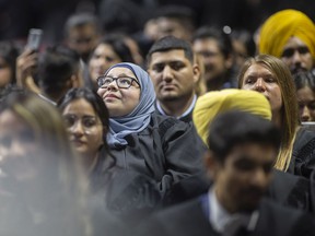 A woman looks up while being seated with fellow graduates at the St. Clair College Convocation at the WFCU Centre, on Wednesday, June 8, 2022.