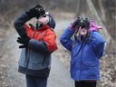 In this Jan. 13, 2019 file photo, local families help out at the Ojibway Nature Center with a children's bird count.  David Flett and Emily Renaud, both 5, use binoculars to spot birds during the event.