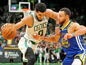 Boston Celtics forward Jayson Tatum handles the ball against Golden State Warriors guard Stephen Curry during the fourth quarter in game six of the 2022 NBA Finals at TD Garden in Boston, June 16, 2022.