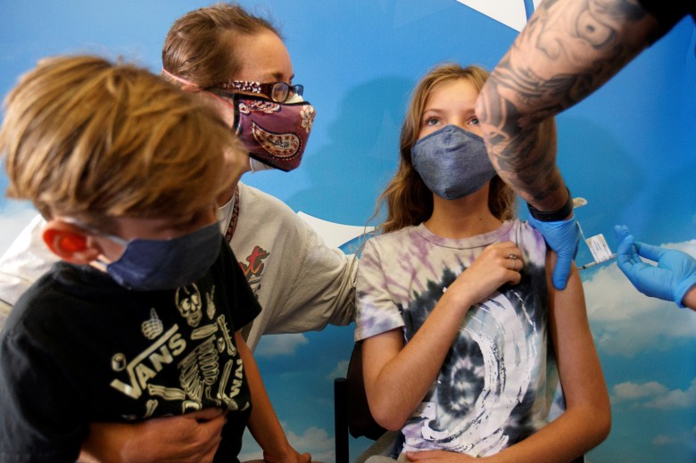 Madeleine Strickland, 11, receives the Pfizer COVID-19 vaccine as her mother Monica and brother Liam look on at Rady's Children's hospital in San Diego on Nov. 3, 2021. REUTERS/Mike Blake