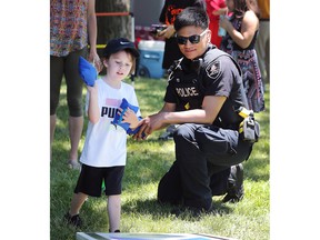 Windsor Police Const.  James Legaspi encourages a youngster playing a game at the Windsor Indigenous Solidarity Day event at the Mic Mac Park on Tuesday, June 21, 2022.