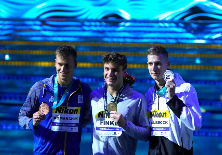 Mykhailo Romanchuk of Ukraine, Bobby Finke of the United States, Florian Wellbrock of Germany pose with their medals after the Men 800m Freestyle final.