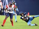 Alouettes receiver Eugene Lewis escapes a tackle attempt by Argonauts' defensive-back Robert Priester during first half action at BMO Field in Toronto Thursday night.
