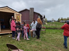 Youths stand outside a shed designed to house sport, game and craft equipment at Kapawe'no First Nation.