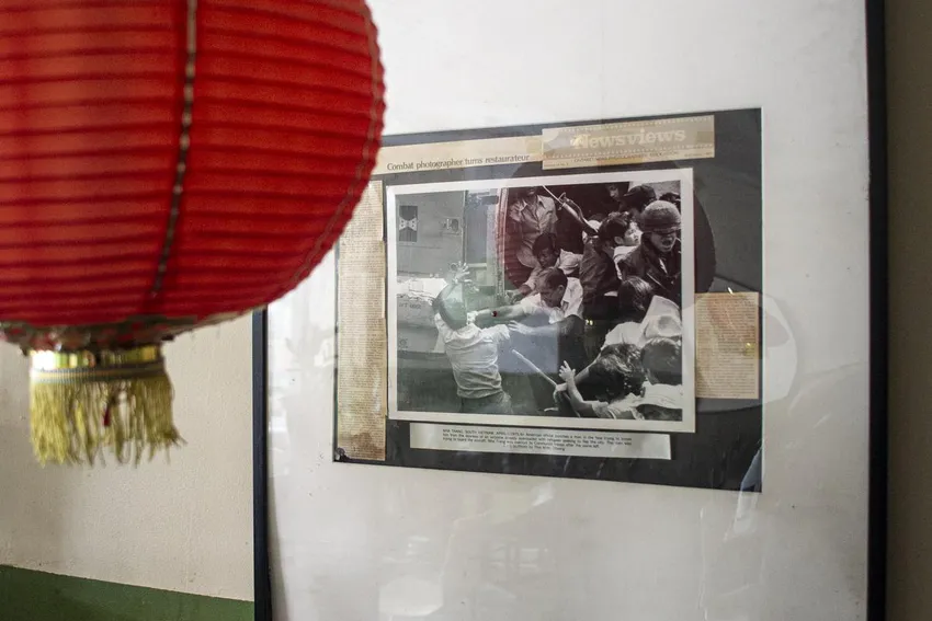 An award-winning photo depicting people trying to evacuate from South Vietnam shot by Rose's late husband, photojournalist Thai Khac Chuong, hangs on the walls of Saigon Flower.