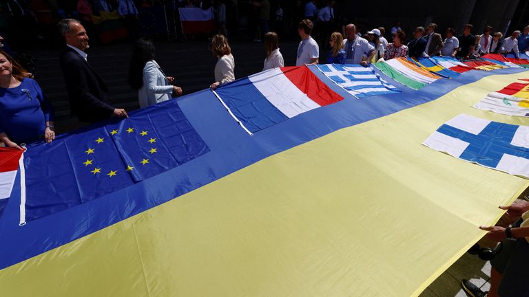 European lawmakers and Ukrainian representatives unfurl a 30 meter long Ukrainian flag in front of the EU Parliament