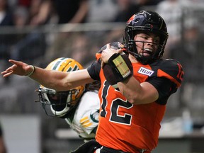 BC Lions quarterback Nathan Rourke (12) is pushed out of bounds by Edmonton Elks' Jalen Collins as he runs with the ball during the first half of CFL football game in Vancouver, on Saturday, June 11, 2022.