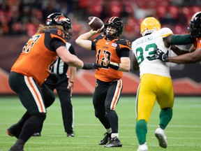 BC Lions quarterback Nathan Rourke passes in the face of the pass rush from the Edmonton Elks' Kwaku Boateng during their Nov. 19, 2021 Canadian Football League game at BC Place Stadium.