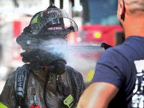 A Windsor firefighter gets debris rinsed off at a house fire on Janette Avenue in Windsor on Friday, June 24, 2022.