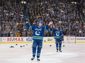 Daniel Sedin and Henrik Sedin, right, of the Vancouver Canucks salute fans after playing in the final home game of their NHL careers on April 5, 2018 at Rogers Arena in Vancouver.