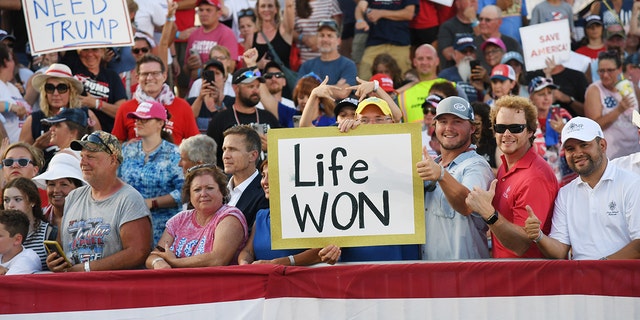 Supporters display signs acknowledging the overturning of Roe v.  Wade during a Save America rally with former US President Donald Trump at the Adams County Fairgrounds on June 25, 2022 in Mendon, Illinois.  (Photo by Michael B. Thomas/Getty Images)