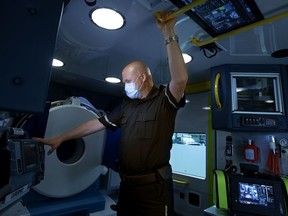 Primary Care Paramedic Kelly Brown poses for a photo in the University of Alberta Hospital Stroke Ambulance, in Edmonton Friday June 10, 2022. The ambulances onboard CT scanner is visible behind Brown.