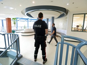 An Edmonton Police Service school resource officer watches the halls at St. Joseph High School, Thursday, May 5, 2022.