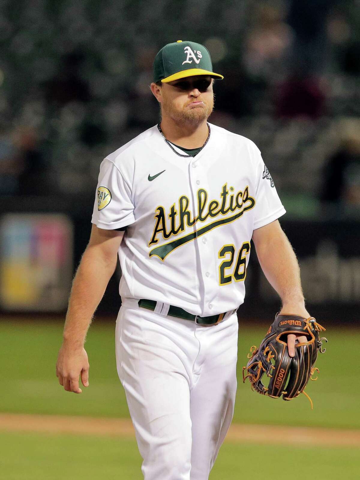 Sheldon Neuse (26) walks off the mound after pitching a perfect ninth inning as the Oakland Athletics play the Seattle Mariners at the Coliseum in Oakland, Calif., on Wednesday, June 22, 2022.