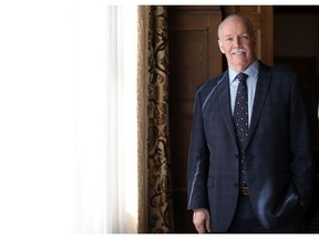 British Columbia Premier John Horgan poses for a portrait after a swearing-in ceremony at Government House in Victoria, Friday, Feb. 25, 2022.