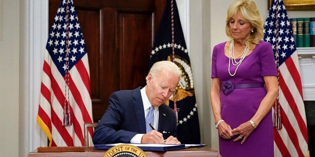 President Biden signs into law S. 2938, the bipartisan Safer Communities Act gun safety bill, in the Roosevelt Room of the White House in Washington, Saturday, June 25, 2022. First Lady Jill Biden looks to the right. 