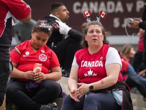 Disappointed Canadian soccer fans sit outside BC Place Stadium on Sunday, June 5, as news comes through that the national men's team's match against Panama has been canceled due to a labor dispute between the team and Canada Soccer, the sport's national body.
