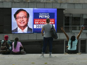 People watch a screen showing preliminary results of the presidential runoff election in Medellin, Colombia, on June 19, 2022.