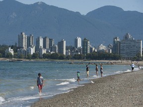People do what they can to stay cool at Kits Beach in Vancouver, BC during a heat wave in August 2021.