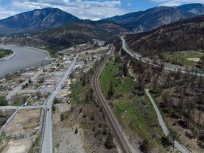 The burned-out remains of businesses and properties destroyed by last year's devastating wildfire are seen along with rail lines, center, and the Trans-Canada Highway, upper right, in Lytton, BC, on Saturday, May 21, 2022. The fire-ravaged community of Lytton, BC, will get  million from the federal government to help it rebuild a fire-resistant and energy-efficient community.