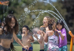 Students from WJ Langlois and William G. Davis elementary schools enjoy the newly installed splash pad at Fountainebleau Park on Friday.