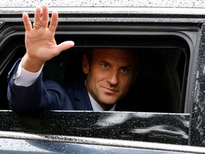 France's President Emmanuel Macron waves as he leaves after casting his vote in the second stage of French parliamentary elections at a polling station in Le Touquet, northern France on June 19, 2022.