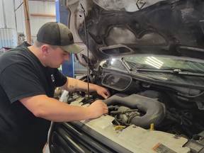 Ryan Reil, a service manager seen here working at Downtown Auto Center in Kitchener, has seen an increase in customers looking to convert their gas-powered vehicles to cheaper propane.