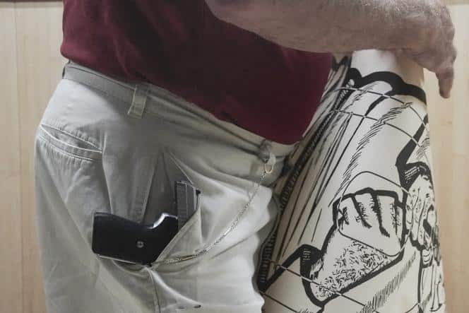 John Deloca, owner of the Seneca Sporting shooting center, a place with a 9mm semi-automatic pistol in his pocket alors qu'il s'apprête à tirer sur une cible, in New York, on June 23, 2022.