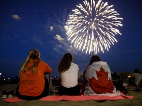 People watch fireworks fly over Ashbridges Bay during Canada Day festivities, on July 1, 2019 in Toronto.
