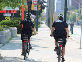 Two London police officers cycle down Dundas Street.  (DALE CARRUTHERS / THE LONDON FREE PRESS file photo)