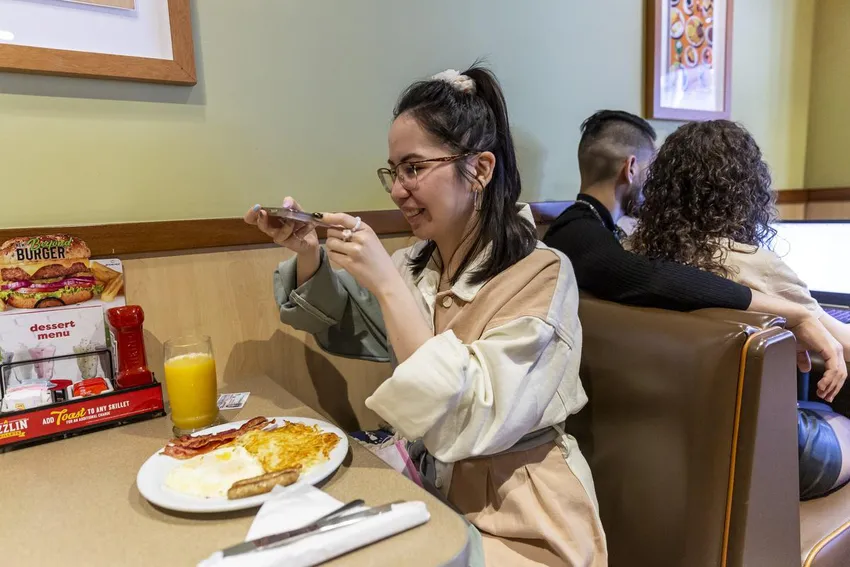 Kendra Seguin, who turned 21 on June 14, takes a photo of her free birthday breakfast at Denny's to send to her mother.
